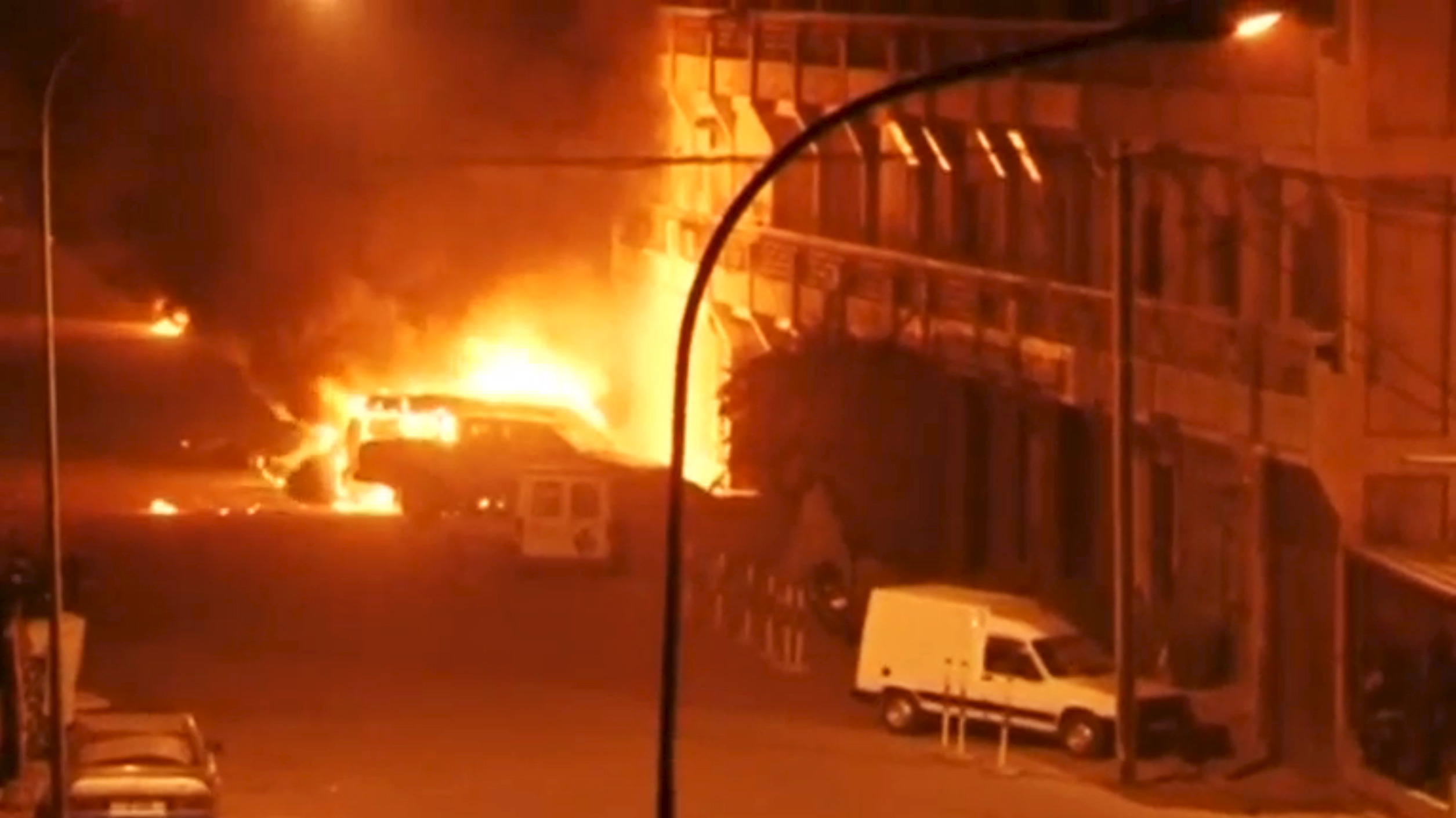 View shows vehicles on fire outside Splendid Hotel in Ouagadougou