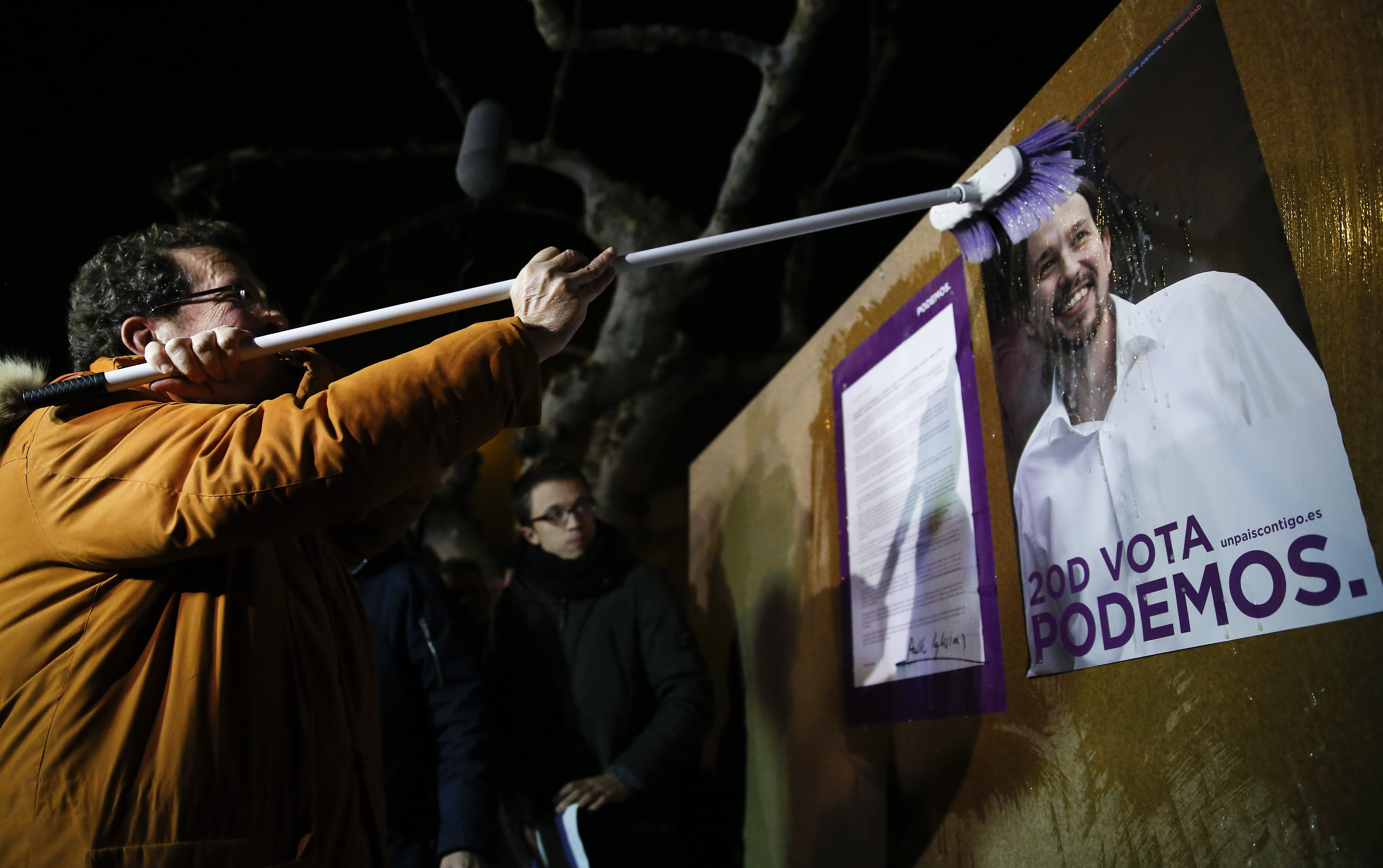 Javier Iglesias, father of Podemos (We Can) party leader Pablo Iglesias, puts up a poster of his son at the start of campaigning for Spain's general election in the village of Villaralbo, Spain, December 3, 2015.  REUTERS/Juan Medina - RTX1X3CU