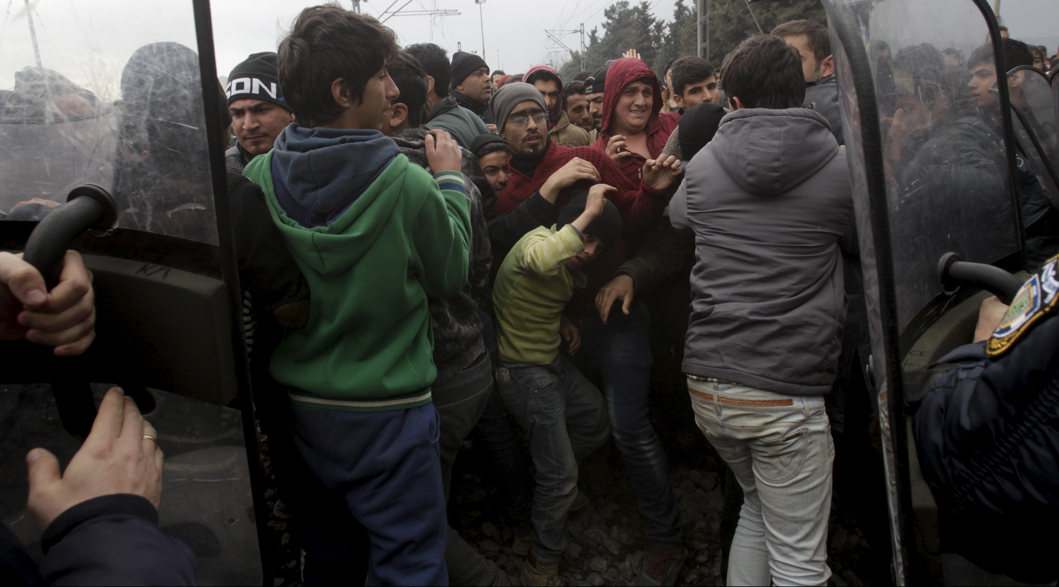 Stranded refugees and migrants are pushed back by Greek riot police after they tried to storm Macedonia from the Greek side of the border during a protest, near the Greek village of Idomeni, February 29, 2016. Macedonian police fired tear gas to disperse hundreds of migrants and refugees who stormed the border from Greece on Monday, tearing down a gate as frustrations boiled over at restrictions imposed on people moving through the Balkans. REUTERS/Alexandros Avramidis - RTS8KG4
