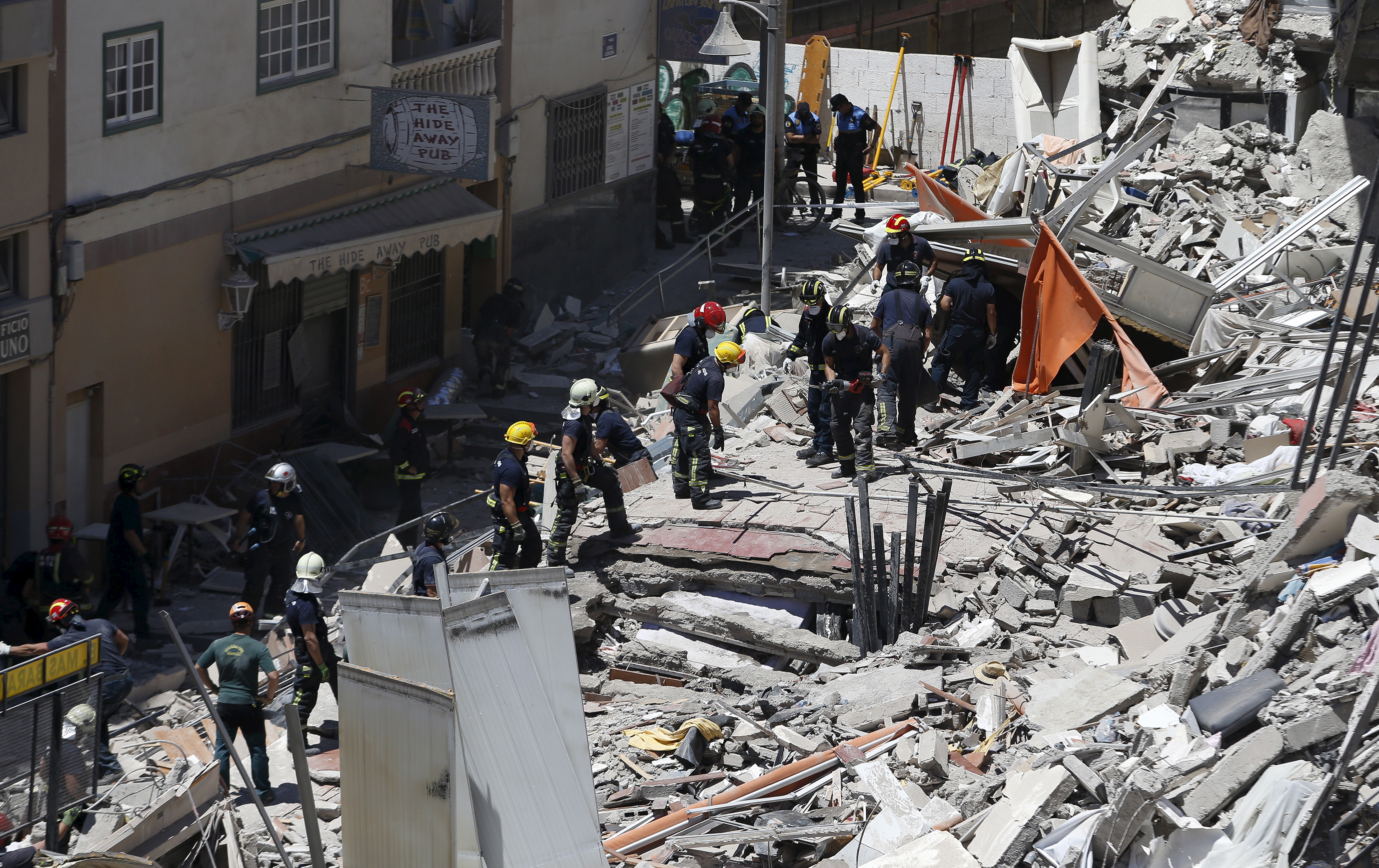 Firefighters and rescue workers search for survivors after a building collapsed in Los Cristianos, in the Canary Island of Tenerife, Spain, April 14, 2016. REUTERS/Santiago Ferrero - RTX29ZFC