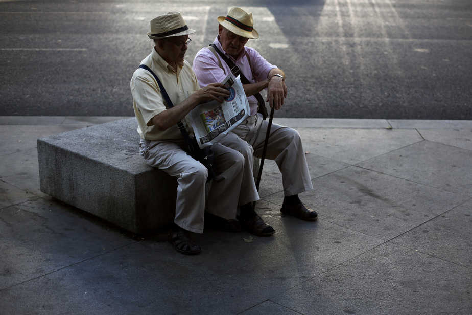 Two elderly men read the paper together in central Madrid September 9, 2014. REUTERS/Susana Vera (SPAIN - Tags: SOCIETY) - RTR45IFX