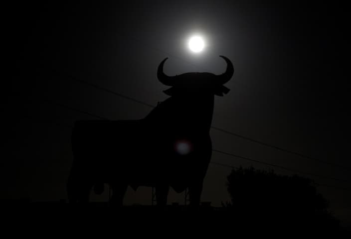 La súper luna se levanta sobre una figura de la cartelera de tamaño de un toro, conocido como el "Toro de Osborne" en El Berrón, cerca de Oviedo. Foto: Reuters