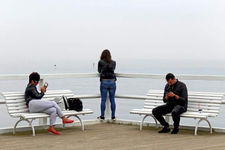 People use mobile phones on the pier at Orlowo beach in Gdynia, Poland September 10, 2016. REUTERS/Radu Sigheti