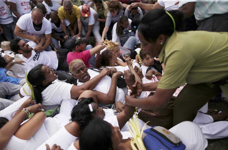 Members of the 'Ladies in White' dissident group shout as they are surrounded by police and government supporters after police broke up the group's regular march, detaining about 50 people, hours before U.S. President Barack Obama arrives for a historic visit, in Havana, March 20, 2016. REUTERS/Ueslei Marcelino