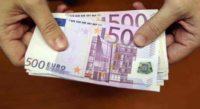 A bank employee holds a pile of 500 euro notes  at a bank branch in Madrid January 13, 2011.   REUTERS/Andrea Comas