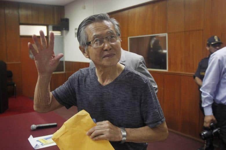 Peru's former President Alberto Fujimori waves to the media as he arrives in court for the sentencing in his trial on charges of embezzling state funds to manipulate the media during his tenure as president, in Lima January 8, 2015.  REUTERS/Enrique Castro-Mendivil