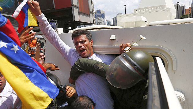 Venezuelan opposition leader Leopoldo Lopez gets into a National Guard armored vehicle in Caracas February 18, 2014. Lopez, wanted on charges of fomenting deadly violence, handed himself over to security forces on Tuesday, Reuters witnesses said. Lopez, a 42-year-old U.S.-educated economist who has spearheaded a recent wave of protests in Venezuela, got into an armored vehicle after giving a speech to an opposition rally in Caracas. REUTERS/Jorge Silva (VENEZUELA - Tags: POLITICS CIVIL UNREST TPX IMAGES OF THE DAY)