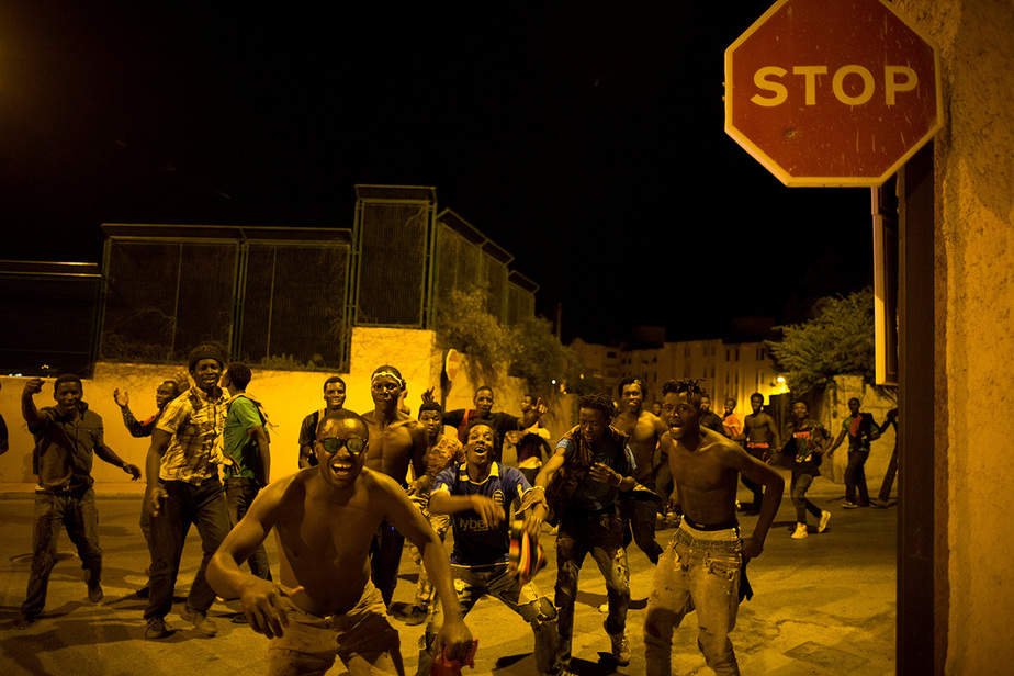 Los inmigrantes africanos reaccionan tras cruzar la frontera desde Marruecos hasta el enclave de Ceuta, España, en el norte de África