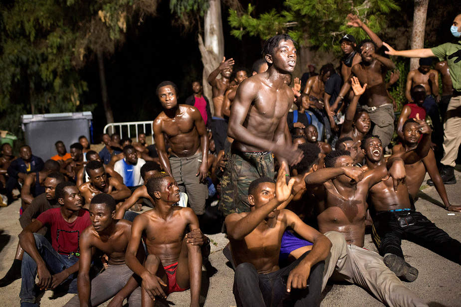 Los inmigrantes africanos reaccionan tras cruzar la frontera desde Marruecos hasta el enclave de Ceuta, España, en el norte de África