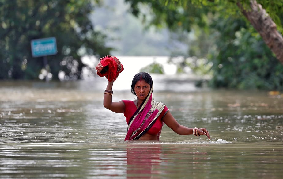 Una mujer atraviesa una aldea inundada en el estado oriental de Bihar, India