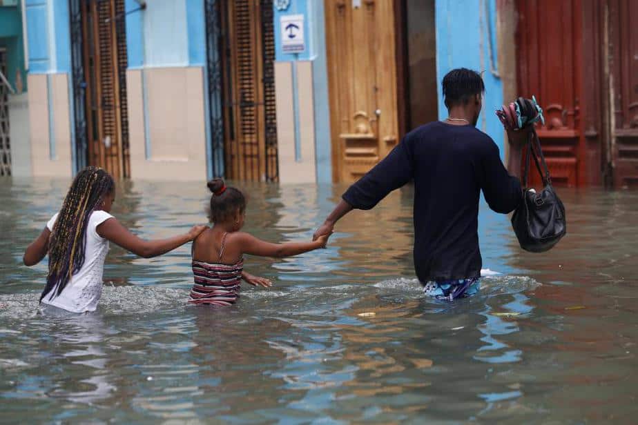 A man and two children wade through a flooded street,  after the passing of Hurricane Irma, in Havana, Cuba September 10, 2017. REUTERS/Stringer