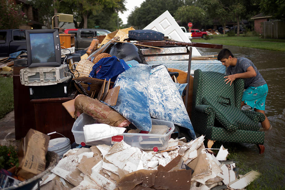 Isaac Zermeno desecha los muebles de la casa de un vecino que quedó inundado de la tormenta tropical Harvey en Houston, Texas.