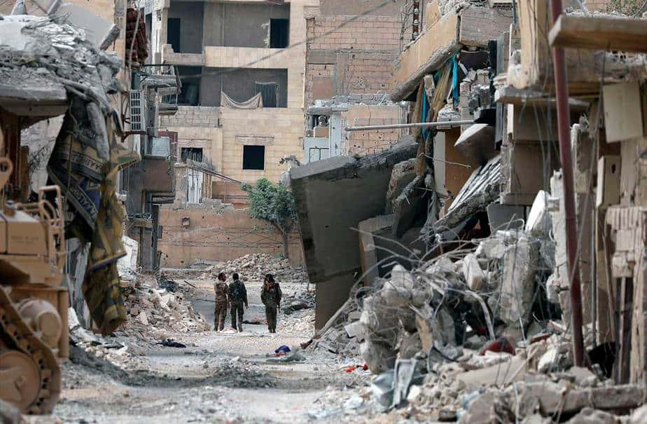 Los cazas SDF caminan juntos a lo largo de una calle dañada en Raqqa el 16 de septiembre de 2017. (Reuters / Rodi Said)