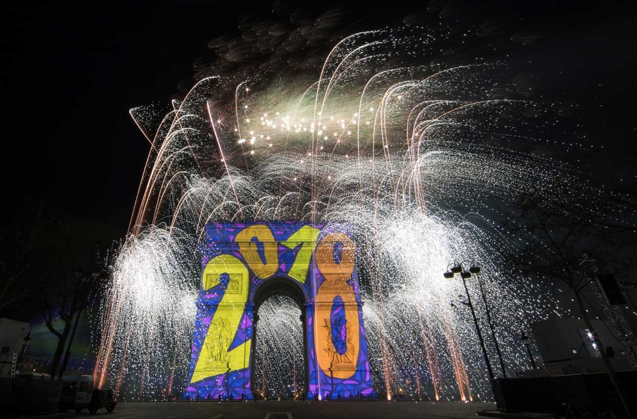 Los fuegos artificiales iluminan el cielo sobre el Arco del Triunfo en la avenida de los Campos Elíseos en París mientras los juerguistas participan en las celebraciones del Año Nuevo, a principios del 1 de enero de 2018. REUTERS