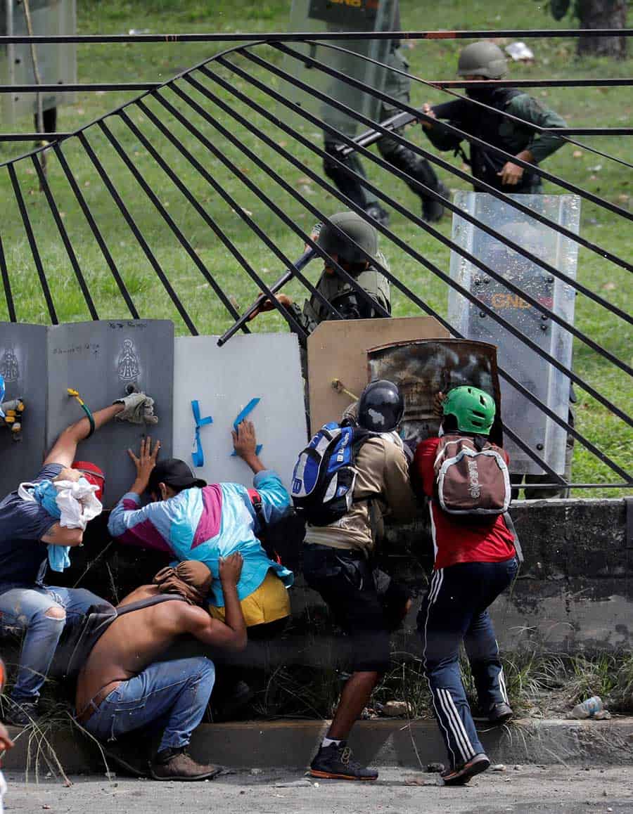 Los manifestantes chocan con las fuerzas de seguridad antidisturbios en la valla de una base aérea mientras se unen contra el presidente de Venezuela, Nicolás Maduro, en Caracas, Venezuela, el 31 de mayo de 2017. REUTERS / Marco Bello