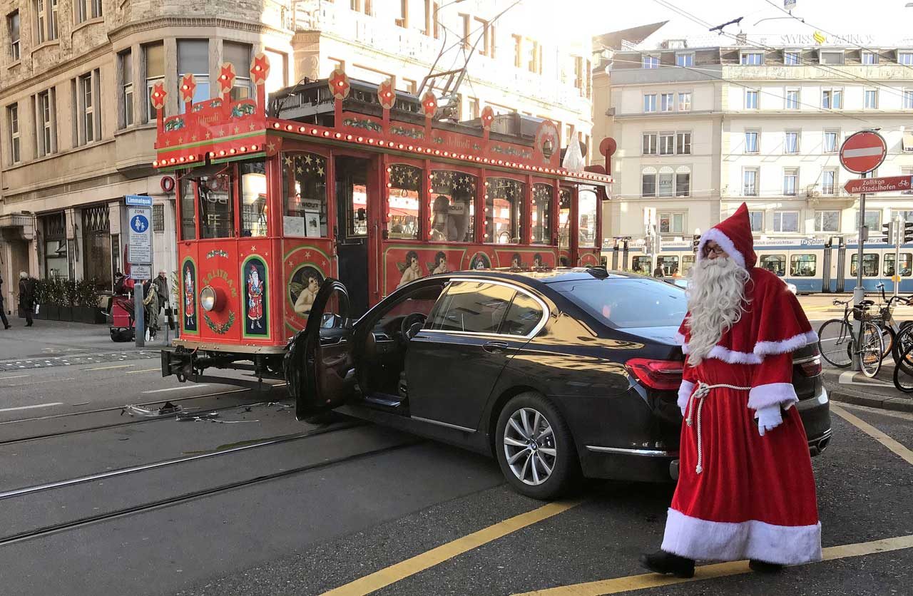 El conductor de un Maerlitram (tranvía de hadas), vestido como un Santa Claus, pasa junto a un automóvil que se estrelló contra el tranvía en Zurich, Suiza. REUTERS
