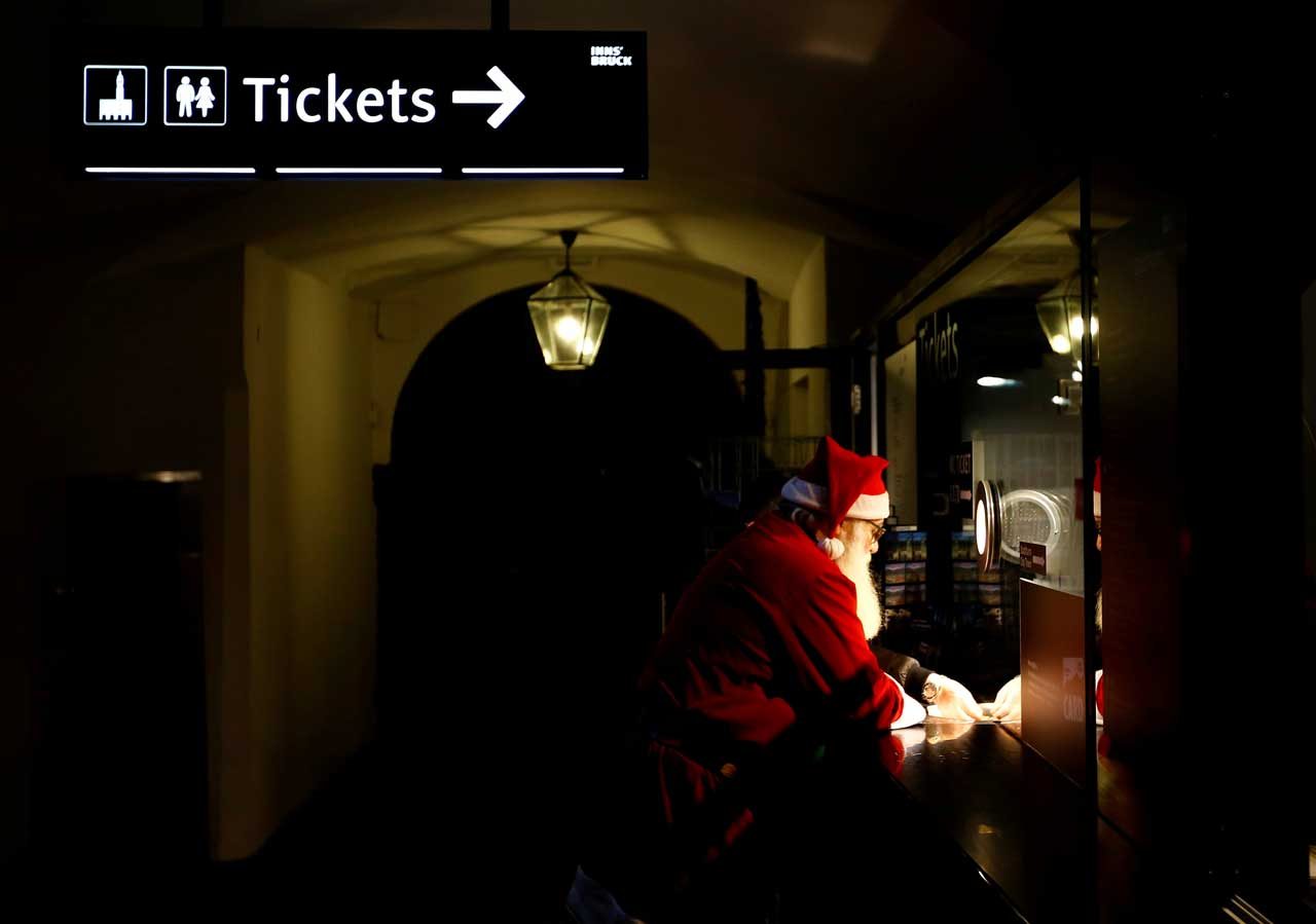 Un hombre vestido como Santa Claus compra un boleto en el mercado de Navidad en Innsbruck, Austria. REUTERS