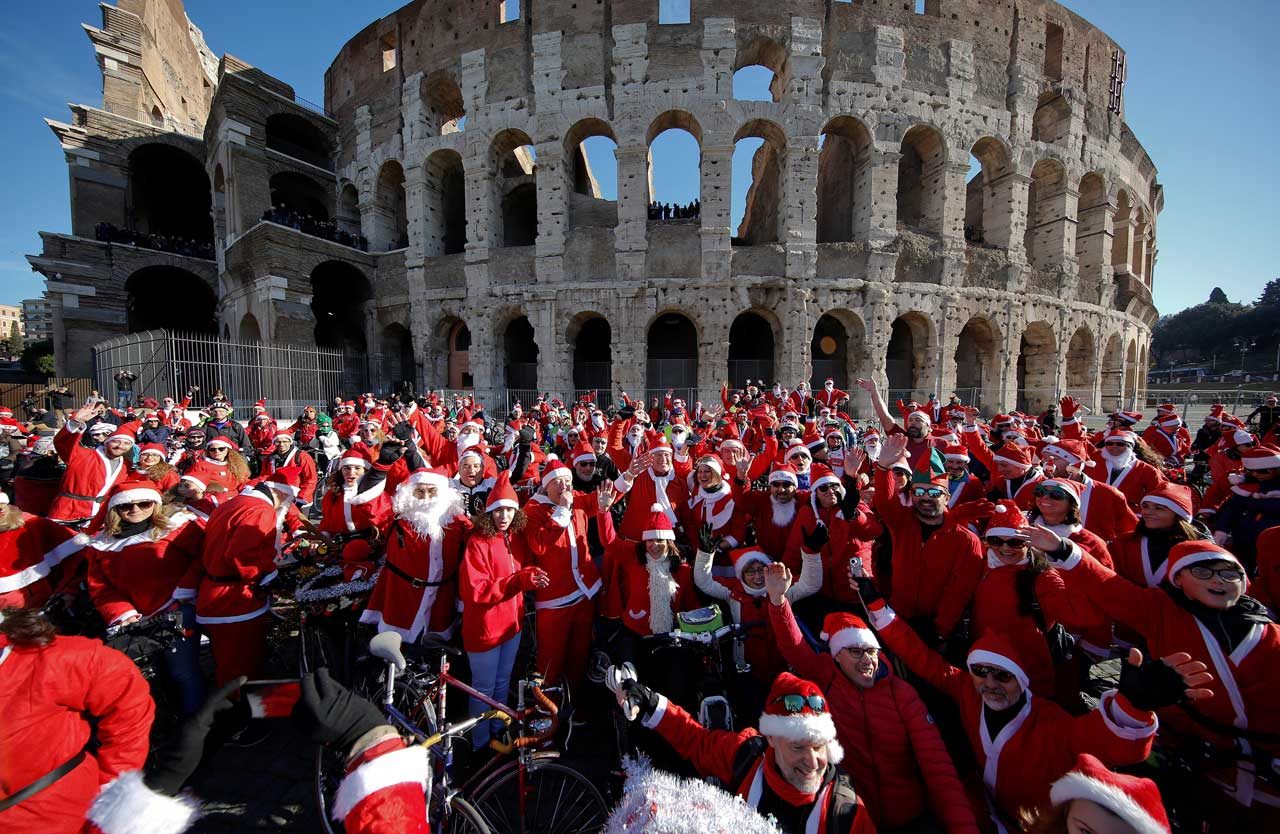 Más de un centenar de ciclistas disfrazados de Santa Claus se reúnen en el Coliseo de Roma, Italia. REUTERS
