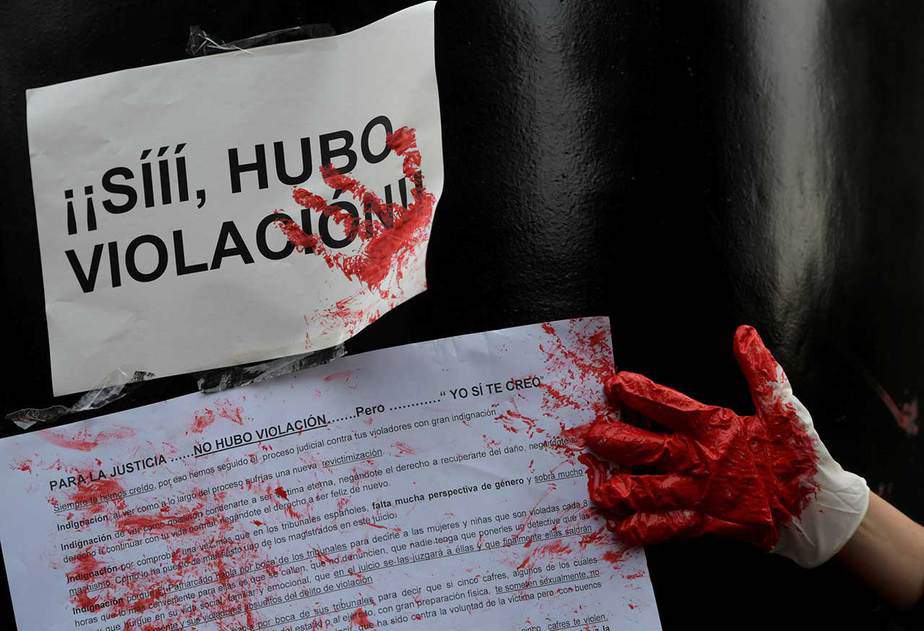 Una mujer pone su mano, manchada con pintura roja, en una pancarta que dice: "Sí, hubo una violación". Oviedo , España, 26 de abril de 2018. REUTERS / Eloy Alonso