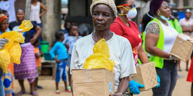 Una mujer mayor recibe en Lagos (Nigeria) comida por parte de organizaciones voluntarias