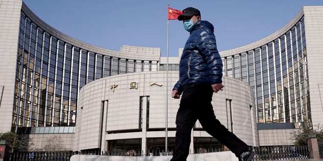 Un hombre con una máscara pasa por la sede del Banco Popular de China, el banco central, en Beijing, China, cuando el país se ve afectado por un brote del nuevo coronavirus, el 3 de febrero de 2020. REUTERS / Jason Lee