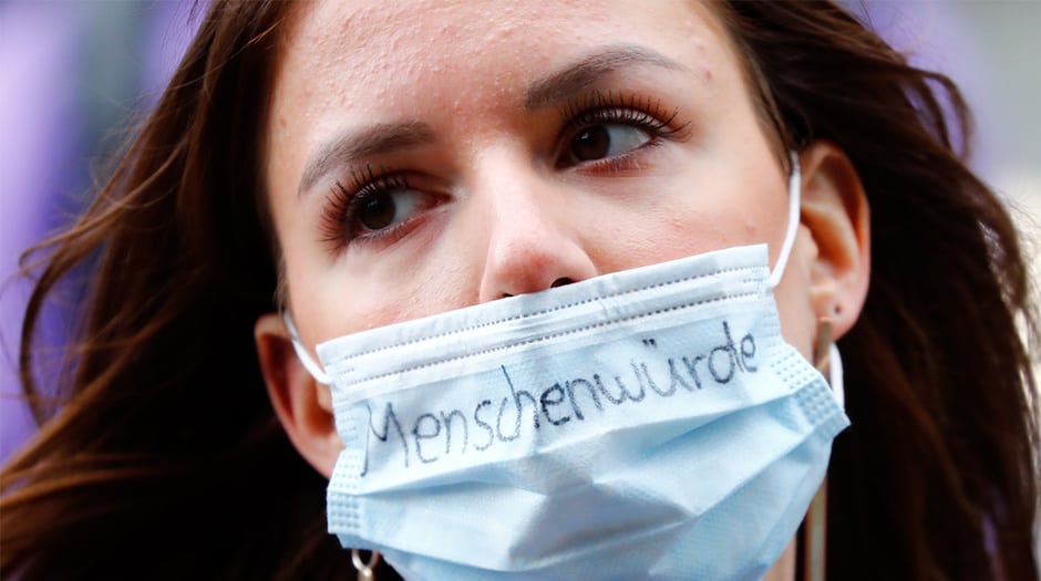 Una enfermera, que escribió en su máscara protectora Dignidad humana, se manifiesta frente al Ministerio de Salud, por un salario más alto y mejores condiciones de trabajo, en medio del brote de la enfermedad por coronavirus (COVID-19) en Berlín, Alemania, el 12 de mayo de 2020