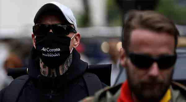 Un manifestante usa una máscara facial que dice "se volvió estúpido por la corona" durante una protesta contra las restricciones del gobierno luego del brote de la enfermedad del coronavirus (COVID-19), en Berlín, Alemania, el 23 de mayo de 2020. Imagen: REUTERS 