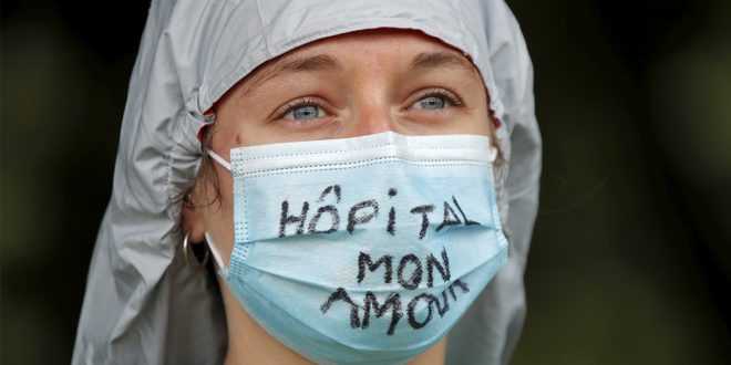 Un trabajador de la salud francés asiste a una protesta en París como parte de un día nacional de acciones para instar al gobierno a mejorar los salarios e invertir en hospitales públicos. Francia el 16 de junio de 2020. El lema dice "Hospital my love". REUTERS / Charles Platiau