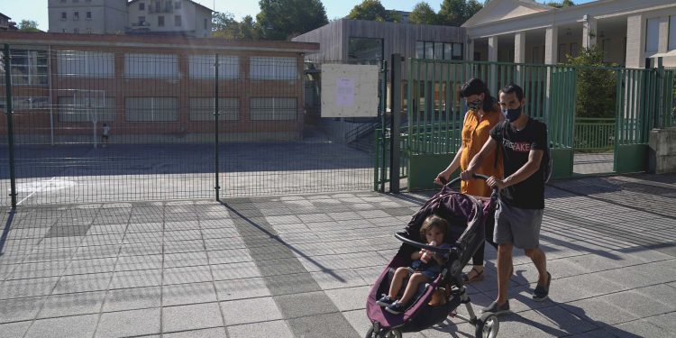 Una pareja pasa por la escuela primaria de Zaldibar después de que las autoridades de la región del País Vasco en España dijeron el jueves que habían cerrado la escuela luego de que varios maestros dieron positivo por la enfermedad del coronavirus (COVID-19), en Zaldibar, España, el 10 de septiembre de 2020. REUTERS / Vincent West