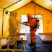 Un miembro del Servicio de Ambulancias ajusta el equipo de protección de su colega, durante la pandemia de la enfermedad del coronavirus (COVID-19), en su sede en Madrid, España. REUTERS / Juan Medina