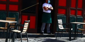 Un camarero con mascarilla protectora espera a los clientes en su terraza en medio del brote de la enfermedad por coronavirus (COVID-19) en Madrid