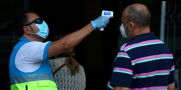 A un hombre le controlan la temperatura antes de una prueba de antígeno de la enfermedad por coronavirus (COVID-19) en Madrid/ REUTERS