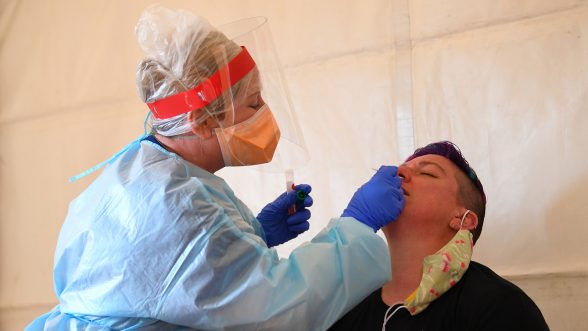 Una trabajadora de la salud examina a un paciente para detectar la enfermedad del coronavirus (COVID-19) en un centro de pruebas en Kilmore, en las afueras de Melbourne, Australia, el 6 de octubre de 2020 / REUTERS
