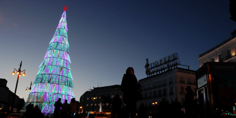 La gente se reúne alrededor de un árbol de Navidad en la plaza Puerta del Sol de Madrid