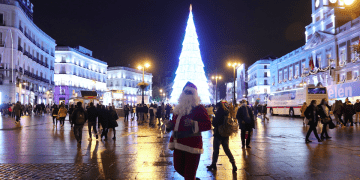 Una artista callejera vestida como Santa Claus camina en la Puerta del Sol en Madrid.(femenino)
