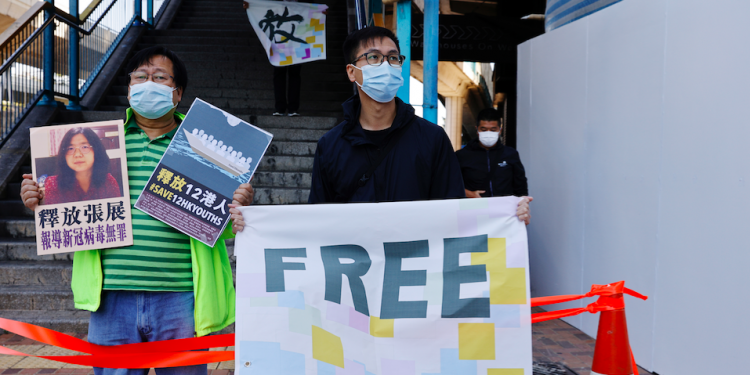 Los partidarios de la democracia protestan para pedir la liberación de 12 activistas de Hong Kong arrestados cuando, según los informes, navegaban a Taiwán en busca de asilo político y al periodista ciudadano Zhang Zhan frente a la Oficina de Enlace de China, en Hong Kong.